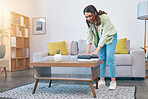 Woman, home and laundry on living room table for hygiene, cleaning and folding for housework in morning. Girl, fabric and cotton towel on desk for organized house, thinking and routine in apartment