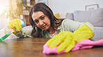 Cleaning table, woman and spray for dust, furniture shine or bacteria on a surface of a house. Smile, working and a girl or cleaner spraying a desk in a living room for housekeeping or home service