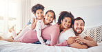 Interracial, happy family and portrait on a bed, bond and having fun on the weekend in their home together. Relax, love and face of playful children with parents in a bedroom, smile and playing games