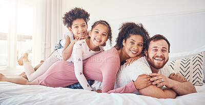 Buy stock photo Interracial, happy family and portrait on a bed, bond and having fun on the weekend in their home together. Relax, love and face of playful children with parents in a bedroom, smile and playing games