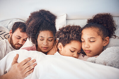 Buy stock photo Family, sleeping and together in bed at home for security, bonding and comfort. Healthy, mixed race and a man, woman and children nap, dream and rest or relax in a bedroom with love, care and peace