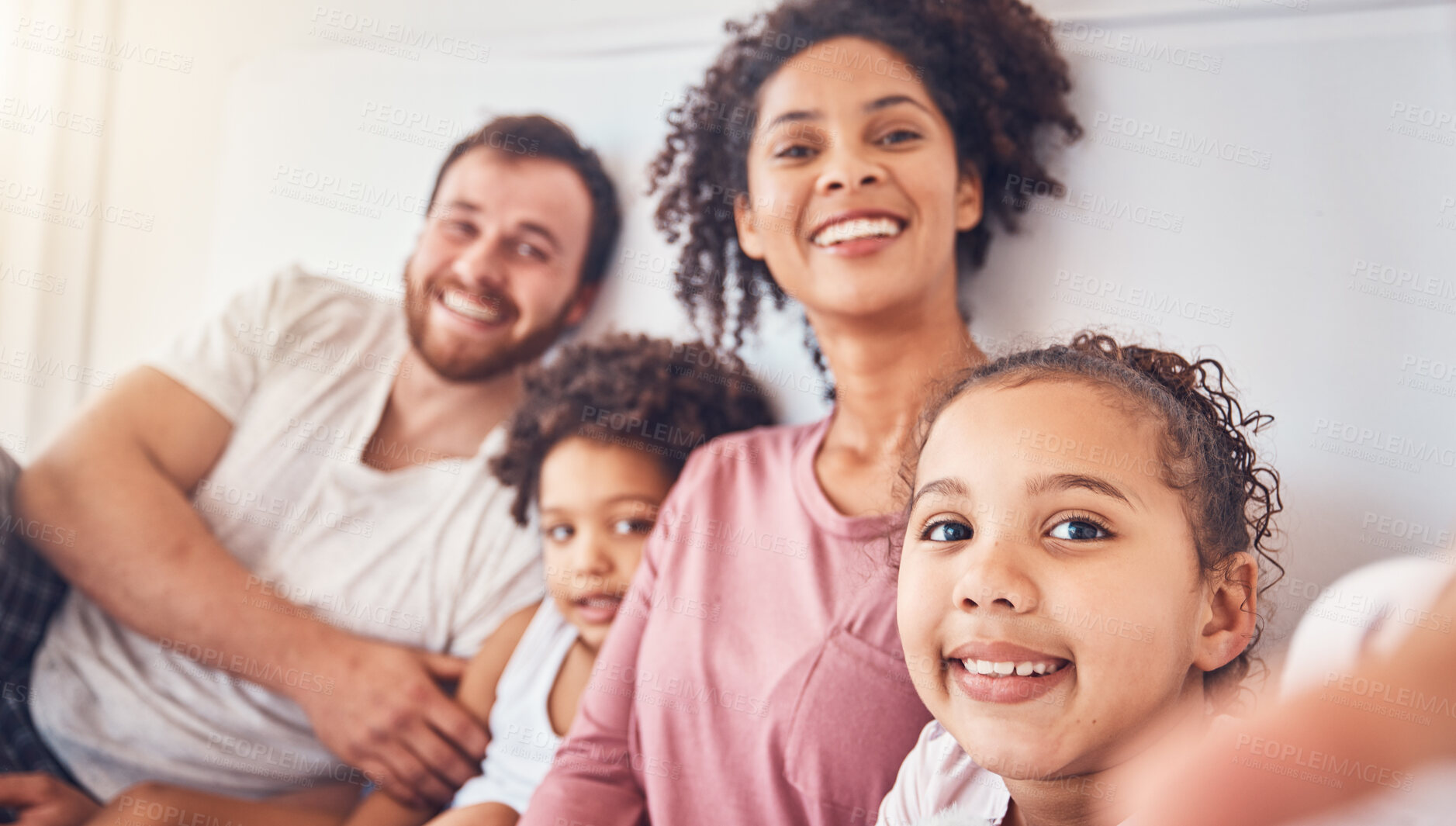 Buy stock photo Happy family, smile and selfie on bed at home for quality time, bonding or morning. Portrait, mixed race and profile picture of a man, woman and children in a bedroom with love, care and comfort