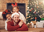Christmas, portrait and happy family in house on floor, bonding and together. Xmas, smile and face of parents with child, interracial and African mother with father for party, celebration and holiday