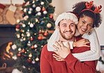 Christmas, portrait and happy couple in home, hug and bonding together. Xmas, smile and face of man with African woman, interracial and enjoying quality time for party, celebration and winter holiday