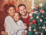 Christmas, happy family and portrait in home, hug and bonding together. Xmas, smile and face of parents with girl, interracial kid and African mom embrace father for party, celebration and holiday