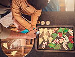 Christmas, above and a family baking cookies, help with food and process of decoration. Hands, child and teamwork for icing sweet dessert or biscuits for a festive holiday in the kitchen together