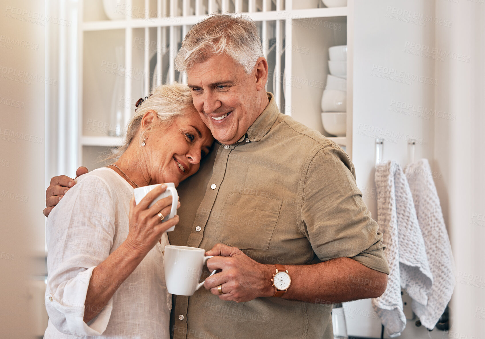 Buy stock photo Coffee, love and retirement with a senior couple hugging in their home together while bonding in the morning. Kitchen, smile or romance with a happy mature man and woman drinking tea in their house
