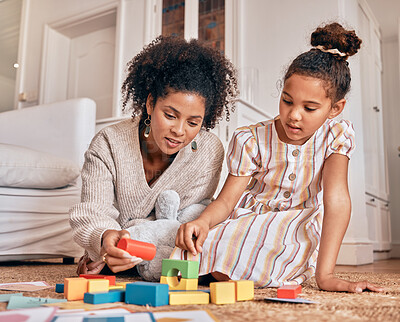 Buy stock photo Family, education and building blocks with a daughter learning from her mother on the floor of their living room. Kids, growth and toys for child development with a woman teaching a girl at home