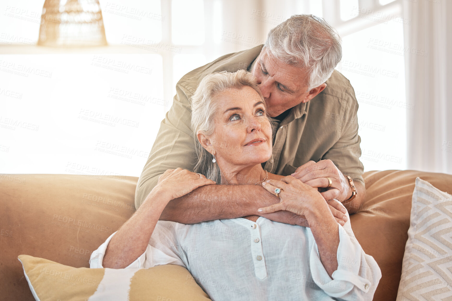 Buy stock photo Old couple, hug and kiss with retirement together, love and care in marriage with people at home. Relax in living room, life partner and pension, man and woman bonding with trust and commitment