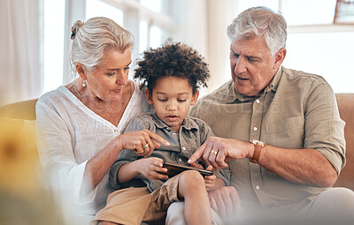 Buy stock photo Grandparents, phone and child in home pointing, learning and bonding together in living room. Smartphone, biracial kid and grandpa and grandma in lounge streaming movie, video or film on social media