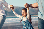 Happy, excited and a child running at the beach on a family vacation, holiday or adventure in summer. Young girl kid holding hands with parents outdoor with fun energy, happiness and love at sea