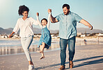 Happy family, swinging and a child at the beach on vacation, holiday or adventure in summer. Young girl kid holding hands and playing with parents outdoor with fun energy, happiness and love at sea
