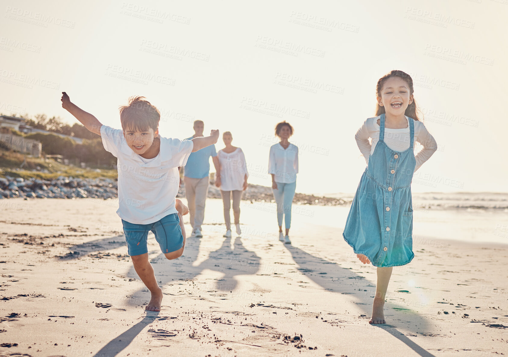 Buy stock photo Happy, excited and children playing on the beach on family vacation, holiday or adventure in summer. Young girl and boy or kids and parents outdoor with fun energy and happiness while playing a game