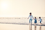 Playing, mother and children at beach on a fun family vacation, holiday or nature adventure at sunset. Young boy and girl holding hands with a woman outdoor for fun energy, happiness and banner space