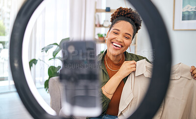 Buy stock photo Fashion, social media and a black woman content creator unboxing a clothes outfit in her home. Live streaming, brand deal and a happy female influencer recording a broadcast for subscription service