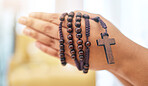 Rosary, praying and hands of woman with gratitude, faith or guidance in her home for help from Jesus christ. Christian, worship and female in prayer with trust, hope and spiritual praise or blessing