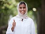 Thumbs up, happy and portrait of Muslim woman in park for support, agreement and yes outdoors. Happiness, smile and face of Islamic female person with hand sign for approval, thank you and success