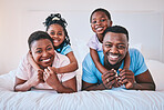 Smile, black family and portrait in a bed happy, care and comfort on the weekend in their home. Face, love and children with parents in bedroom playing, hug and relax while having fun together