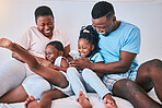 Laugh, black family and tickle in a bed with smile, care and happy on the weekend in their home. Happy, playing and children with parents in bedroom with games, laughing and having fun together