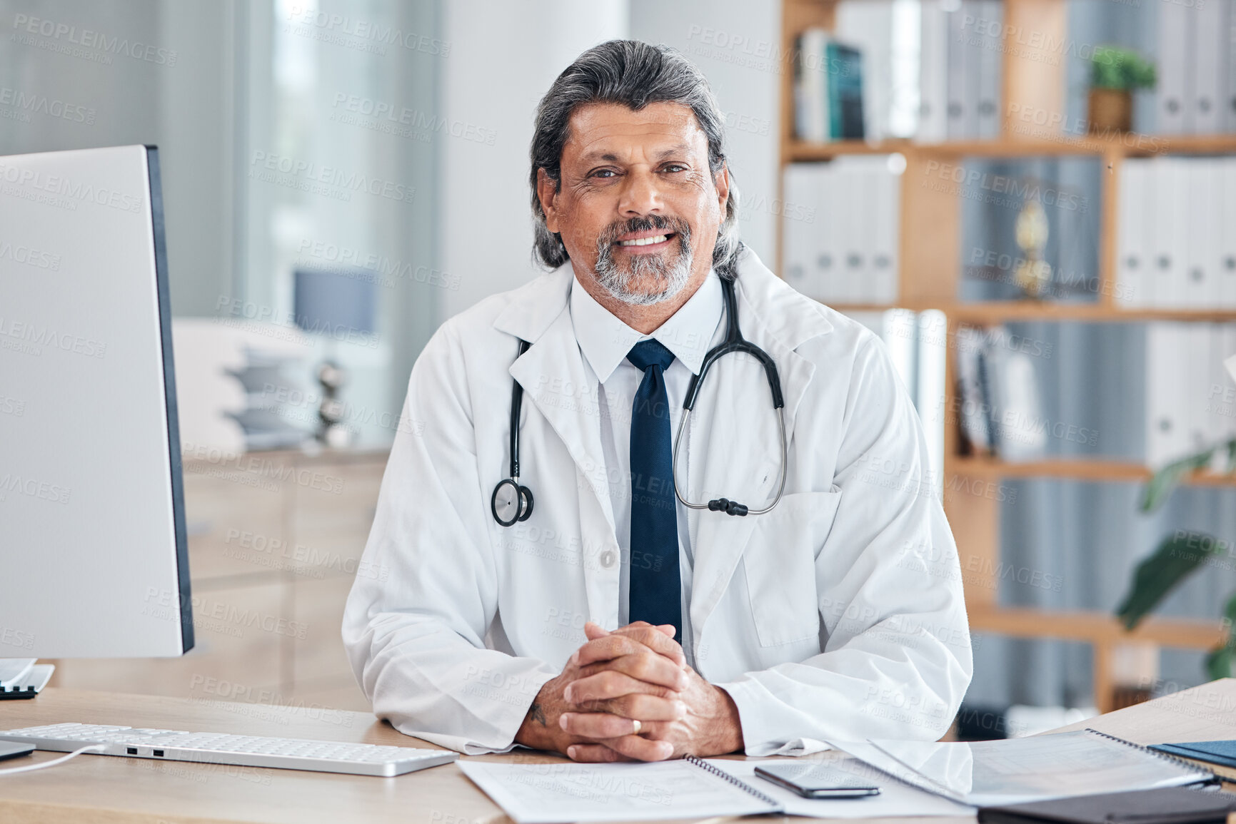 Buy stock photo Doctor, portrait and man in healthcare office for consultation, support and services or advice at table. Happy face of medical worker or senior person with health insurance in clinic or hospital