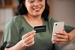 Hands, woman and a credit card and phone for online shopping, banking app or ecommerce on the sofa. Smile, house and closeup of a girl with a mobile for retail, payment or online finance on the couch