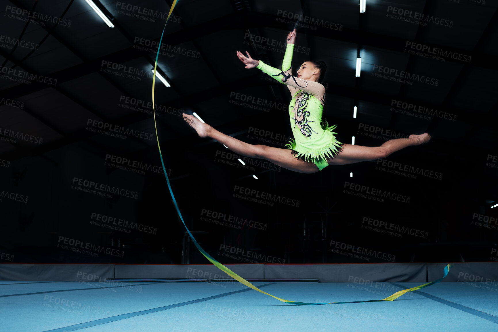 Buy stock photo Jump, rhythmic gymnastics and woman in gym with ribbon, creative sport or action, performance or fitness. Competition, athlete and female gymnast, dance and art with body, routine and energy at arena