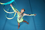 Dance, rhythmic gymnastics and woman in gym with ribbon in air,  action with performance and fitness. Competition, athlete and female gymnast, creativity and art with routine and energy at arena