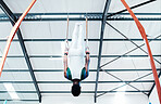 Gymnastics, rings and man at gym for fitness, workout and body, performance or training. Balance, exercise and guy acrobat at sports studio for athletics, resilience and cardio, hanging or endurance