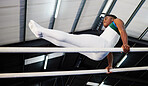 Strength, fitness and gymnast or male athlete with practicing  for competition with african at the gym. Gymnastics, sports and african man with balance on beam for training with flexibility at arena.