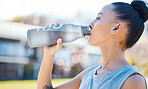 Drinking water, fitness and woman for outdoor training, exercise and workout nutrition, health or wellness in park. Tired runner or athlete person with liquid bottle for running energy and cardio