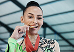 Medal, winner and portrait of woman with success in competition, gymnastics or gold, award and prize from achievement in tournament. Winning, athlete and celebration on podium in stadium or arena