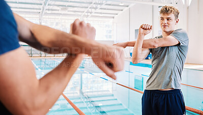 Buy stock photo Man, swimmer and stretching with personal trainer for exercise, training or workout by indoor pool. Male person or athlete in body warm up with fitness coach getting ready for swimming competition