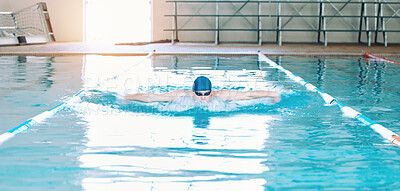 Swimming, sports and man in pool at gym for training, competition and exercise in water. Professional swimmer, fitness and male person practice for challenge, workout and performance for wellness