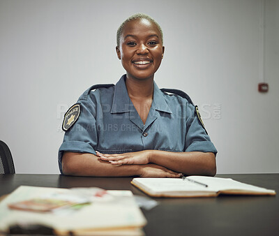 Buy stock photo Happy, smile and portrait of a female police officer sitting by a desk in the office writing reports. Confidence, happiness and African woman security guard with a positive mindset in the workplace.