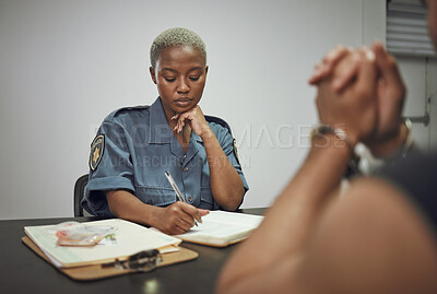 Buy stock photo Security, criminal and female police officer at the station writing a legal report for social justice. Law enforcement, crime and male thief in handcuffs talking to woman guard in interrogation room.