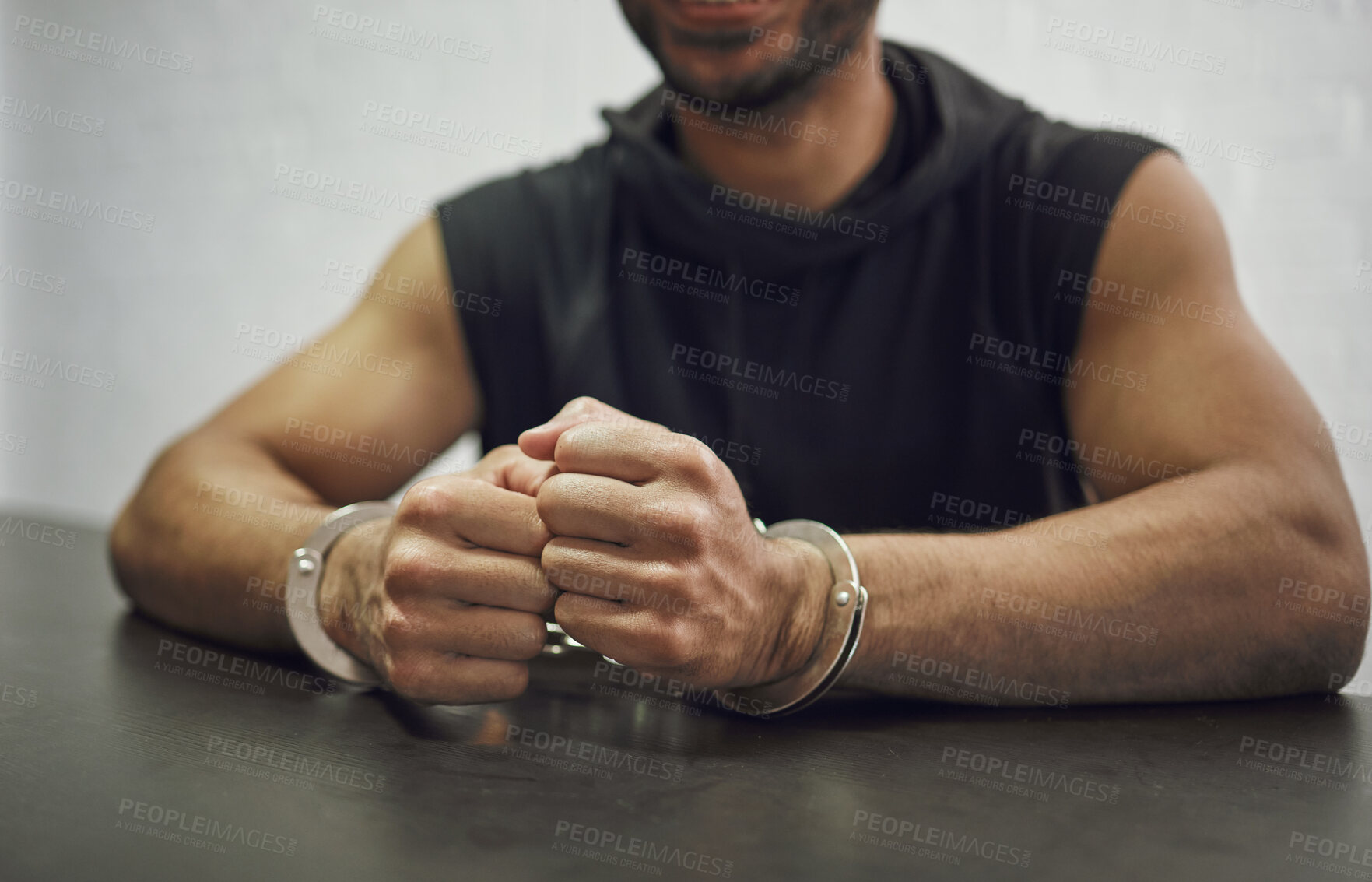 Buy stock photo Man, criminal and handcuffs for interrogation, crime or money laundering in arrest on table in room. Closeup of male person, gangster or suspect in jail, justice or guilty for fraud, theft or scam