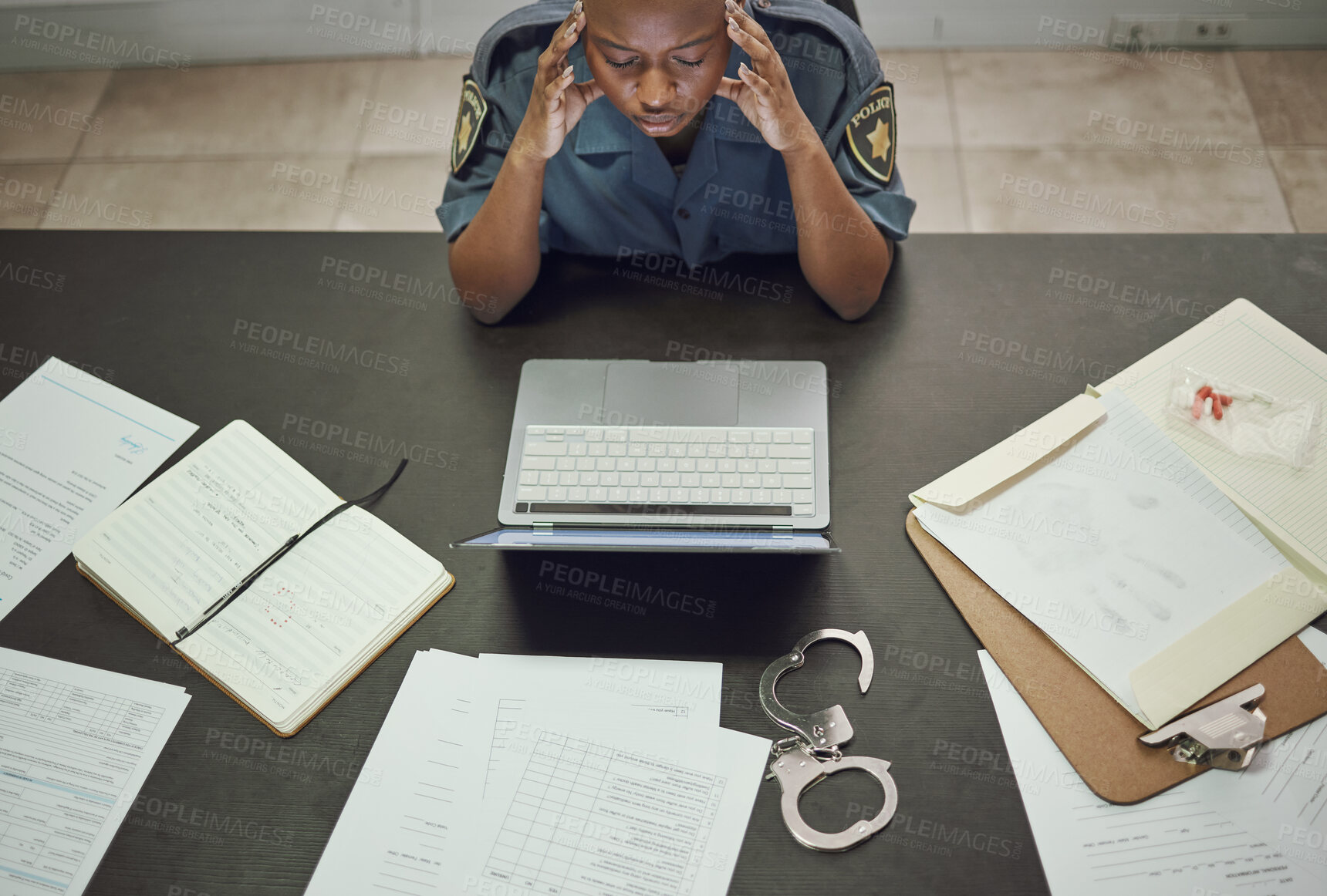 Buy stock photo Police, woman and working with stress at desk with documents, paperwork or frustrated with headache from working on computer case, report. Security, officer and tired from work in office or station