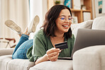 Relax, laptop and credit card, happy woman on couch in living room for internet banking in home for online shopping. Ecommerce payment, smile and cashback, girl on sofa with computer and website sale