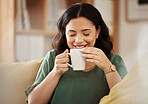 Coffee, relax and smile with a woman in her home, sitting on a sofa in the living room enjoying a beverage. Peace, quiet and eyes closed with a happy young female person drinking tea in her house