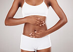 Body, hands and stomach of a woman for health and wellness on a white studio background. Fitness, gut and diet of aesthetic female model for weight loss, colon balance or digestion and motivation