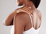 Black woman, back pain and injury with health issue, muscle tension and inflammation on a grey studio background. Female person, body ache or model with joint strain, sore and swollen with stress