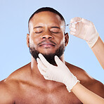 Needle, scared man and plastic surgery of skincare process, filler and aesthetic prp in studio. Face of black male model with fear, pain and anxiety for injection, facial change and blue background