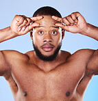 Hair loss, problem and portrait of black man with small sign in studio worried about forehead size on blue background. Hairline, crisis and face with African male model with anxiety for alopecia