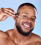 Black man, portrait and serum for face in studio, aesthetic skincare or dermatology on blue background. Happy male model, facial cosmetics and dropper of hyaluronic acid, collagen and oil for beauty