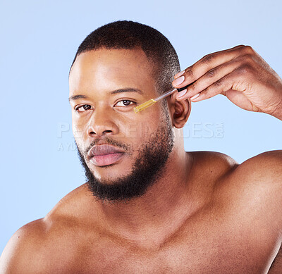 Buy stock photo Man, portrait or face oil in studio, aesthetic skincare or beauty dermatology on blue background. Serious black male model, facial cosmetics or dropper of hyaluronic acid, collagen or vitamin c serum