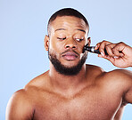 Man, shave and worry with face razor for hair removal, aesthetic skincare and facial cleaning in studio. Scared black male model shaving beard with blade, trimmer or cosmetic tool on blue background