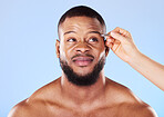 Beauty, tweezers and young man in a studio for grooming his eyebrows for face epilation. Health, hygiene and male model with facial hair removal treatment for self care isolated by a blue background.