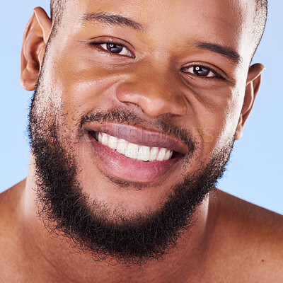 Buy stock photo Cosmetics, closeup and black man with skincare, dermatology and grooming against a blue studio background. Male person, beard or model with treatment, face and glow with aesthetic, self care or smile