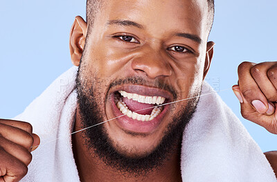 Buy stock photo Portrait, man and floss teeth in studio, health dental and self care of gum gingivitis. Face of black male model, thread or cleaning mouth for fresh breath, tooth hygiene or plaque on blue background