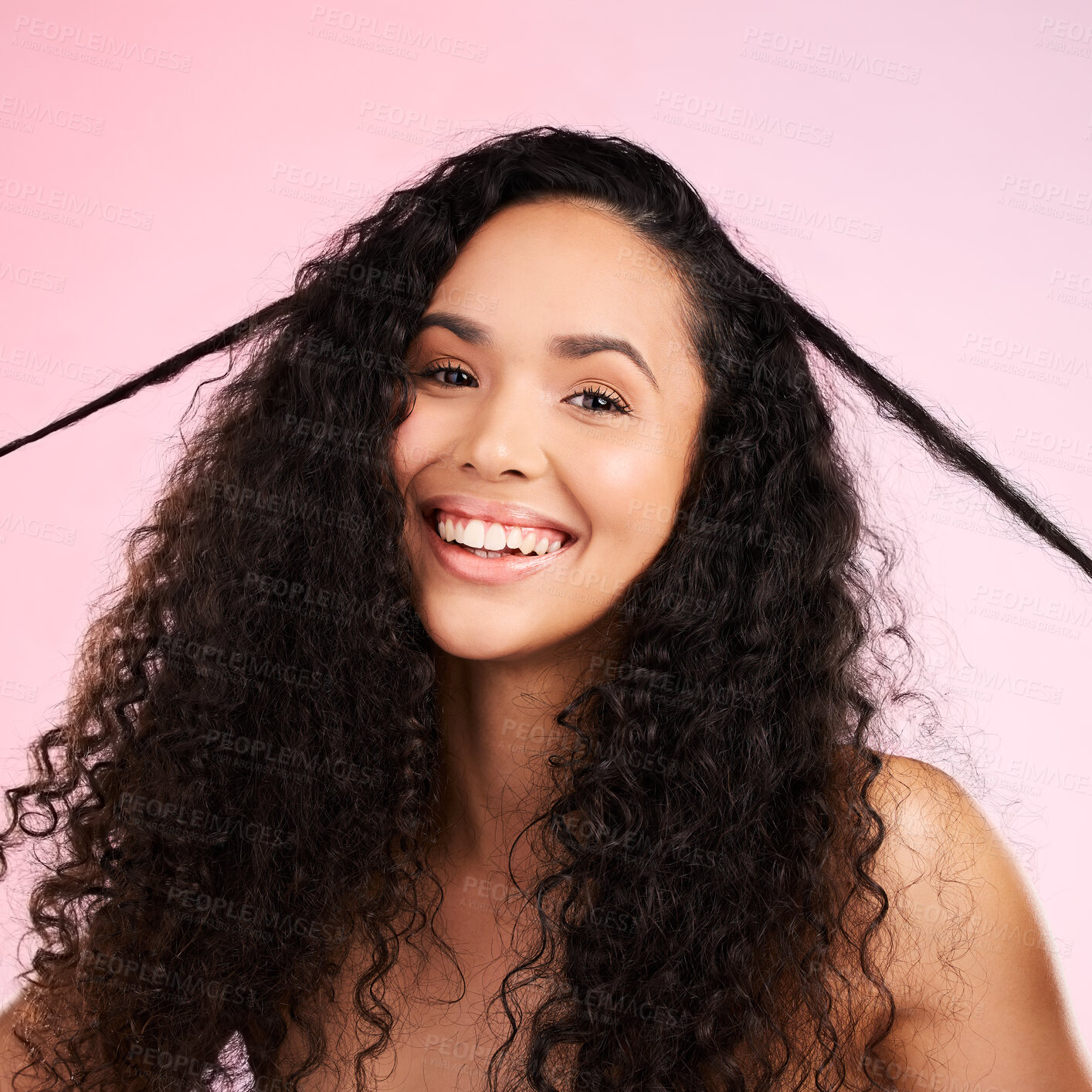 Buy stock photo Face, woman and curly hair pull for beauty in studio isolated on a pink background. Portrait, natural cosmetics and hairstyle of happy model in salon treatment for growth, wellness and aesthetic